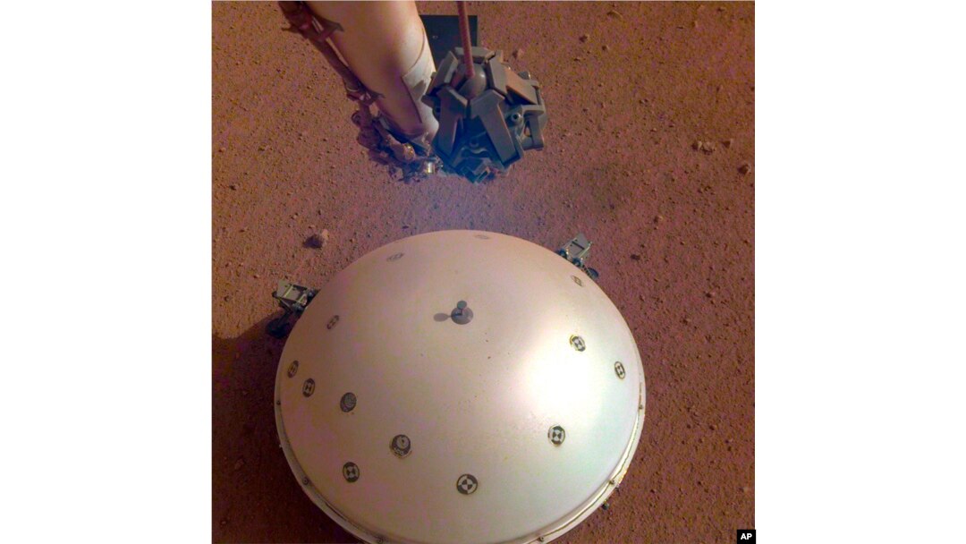 This photo made available by NASA on Tuesday, April 23, 2019 shows the Mars InSight lander's domed wind and thermal shield which covers a seismometer. (NASA/JPL-Caltech via AP)
