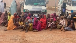 FILE - Women and children who were kidnapped in the northwestern state of Zamfara, sit after being rescued by the Nigerian security agents in Zamfara, Nigeria, October 7, 2021.