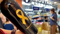 香港市民丁小姐在沙田一間阿布泰分店排隊約40分鐘，購買阿布泰獨家發售，2019年釀製、貼上象徵自由的黃絲帶及香港加油標貼的紅酒 (美國之音湯惠芸)