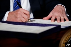 El presidente Donald Trump firma la ley de Responsabilidad y Protección de Denunciantes del Departamento de Veteranos 2017. Junio 23, 2017.
