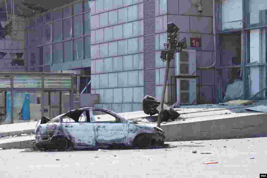 天津爆炸事故現場,核心爆炸區週圍多座居民樓窗戶被震碎,高速公路橋樑受損,多輛大貨車被炸翻,小汽車起火或被砸,多名當地居民仍逗留在事故現場。(美國之音記者東方拍攝)
