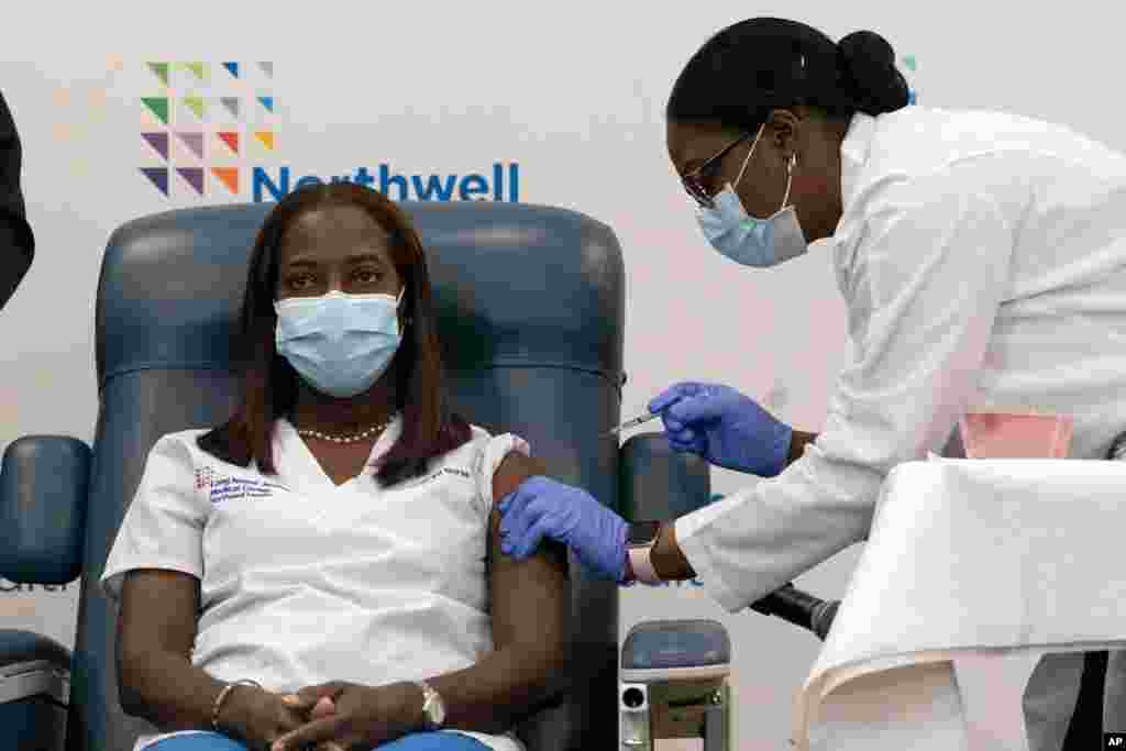Sandra Lindsay, left, a nurse at Long Island Jewish Medical Center, is inoculated with the Pfizer-BioNTech COVID-19 vaccine by Dr. Michelle Chester in the Queens borough of New York.