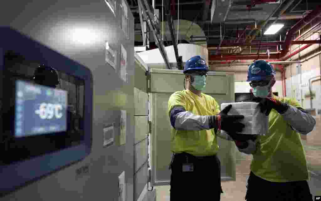The temperature on a freezer reads -69°C as workers move boxes containing the Pfizer-BioNTech COVID-19 vaccines to be shipped at the Pfizer Global Supply Kalamazoo manufacturing plant in Portage, Michigan.