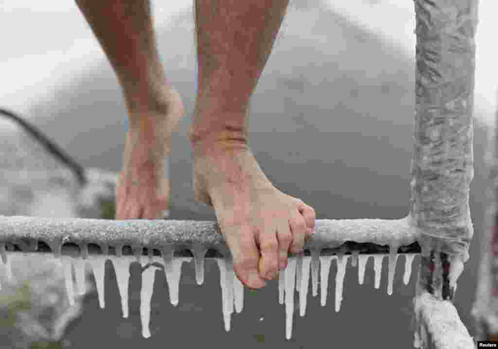 A man descends an icy ladder before immersing into the icy waters of the Irtysh River on the opening day of the winter swimming season in Omsk, Russia.
