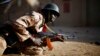 A Malian soldier takes cover behind a truck during exchanges of fire with jihadists in Gao, northern Mali, Feb. 10, 2013.