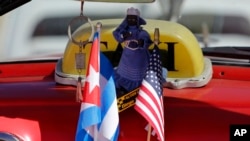 Les étoiles et les rayures et le drapeau national cubain sont réunis sur le tableau de bord d'un cabriolet American à La Havane, Cuba, le 18 février 2016.