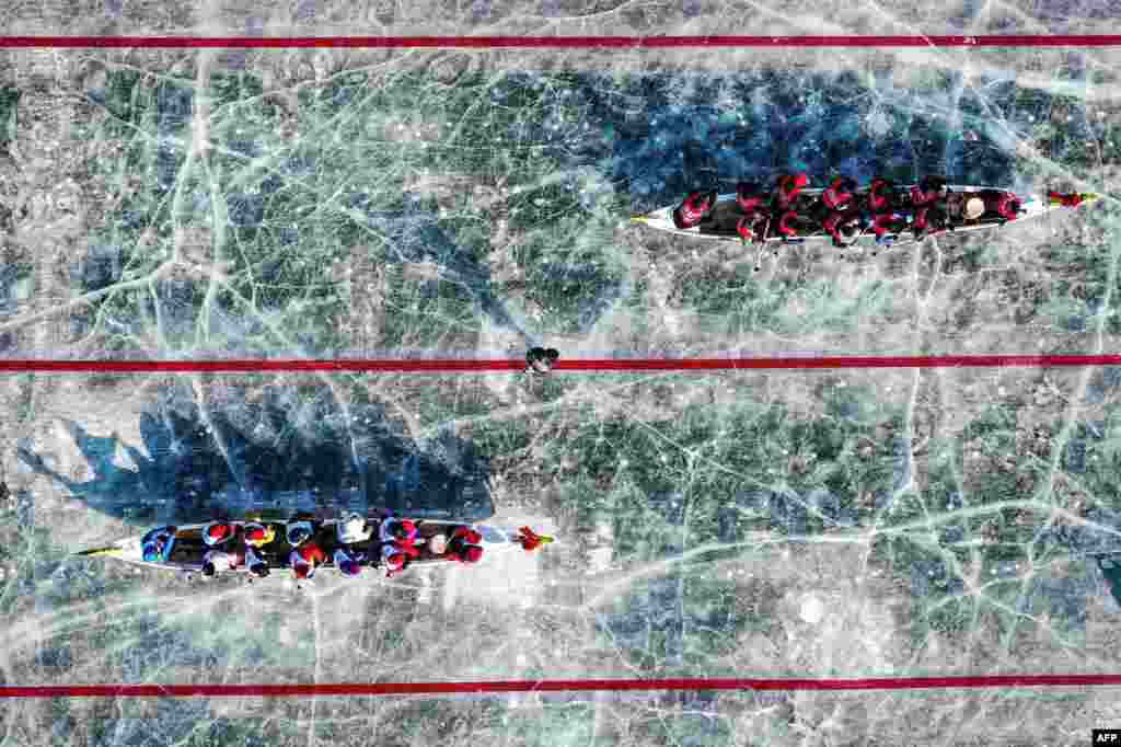 This aerial view shows teams competing during an ice dragon boat race on a frozen river in Shenyang, in northeastern China's Liaoning province.