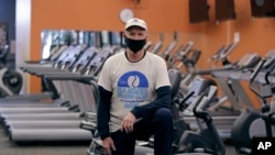 In this April 21, 2020 photograph, Laury Hammel, CEO and founder of the Longfellow Health Clubs and the Salt Lake Tennis and Health Club, poses at the Wayland, Mass. facility, closed due state COVID-19 restrictions.