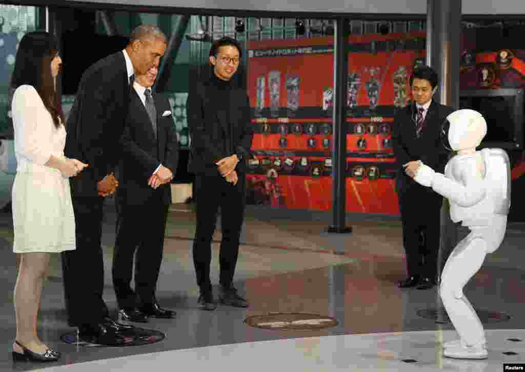 Presiden AS Barack Obama (kedua dari kiri) membungkuk kepada robot "Asimo" saat mengunjungi Miraikan atau Museum Ilmu Pengetahuan dan Inovasi di Tokyo, Jepang.