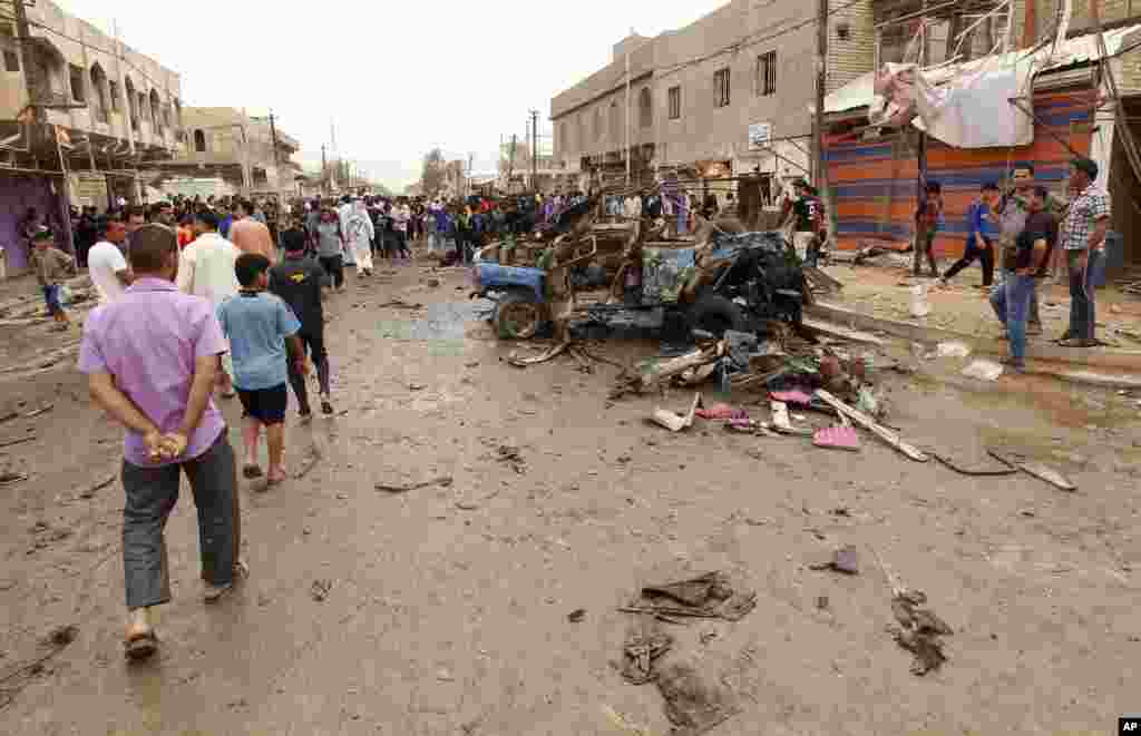 People look at the scene of a car bomb attack in a predominantly Shi'ite area of eastern Baghdad, May 20, 2013.