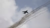 FILE - A Nigerian air force fighter jet flies behind trails of smoke above Kwenev airbase, on the outskirts of Makurdi, Nigeria, April. 21, 2017. A similar jet was shot down Monday by an armed criminal gang.