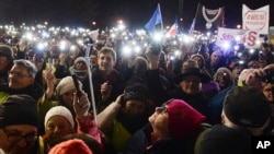 FILE - People take part in a street protest to show solidarity with judges facing increased political pressure from the country's right-wing government, in Warsaw, Poland, Dec. 1, 2019.