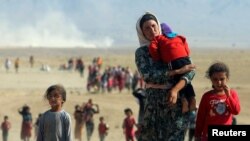 Orang-orang Yazidi, melarikan diri dari kekerasan dari pasukan yang setia kepada ISIS di kota Sinjar, berjalan menuju perbatasan Suriah di pinggiran gunung Sinjar dekat perbatasan Suriah. (Foto: Reuters)