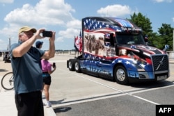 Un hombre toma una fotografía mientras un desfile de motocicletas y camiones llamado Rolling To Remember, anteriormente conocido como Rolling Thunder, llega a Washington, DC, el 26 de mayo de 2024.