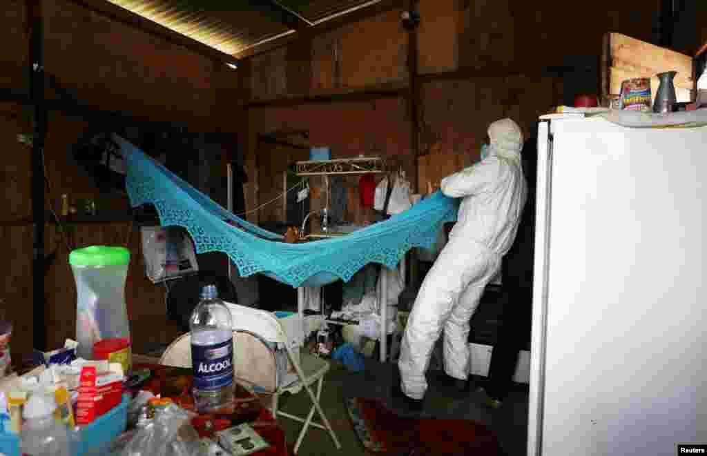 A municipal healthcare worker examines the body of Rocimar Fernandes dos Santos, who died at home at the age of 43 after reporting symptoms consistent with COVID-19 in Manaus, Brazil, Jan. 12, 2021.