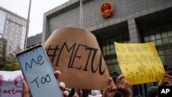 Supporters hold banners as they wait for of Zhou Xiaoxuan outside at a courthouse where Zhou is appearing in a sexual harassment case in Beijing on Dec. 2, 2020.