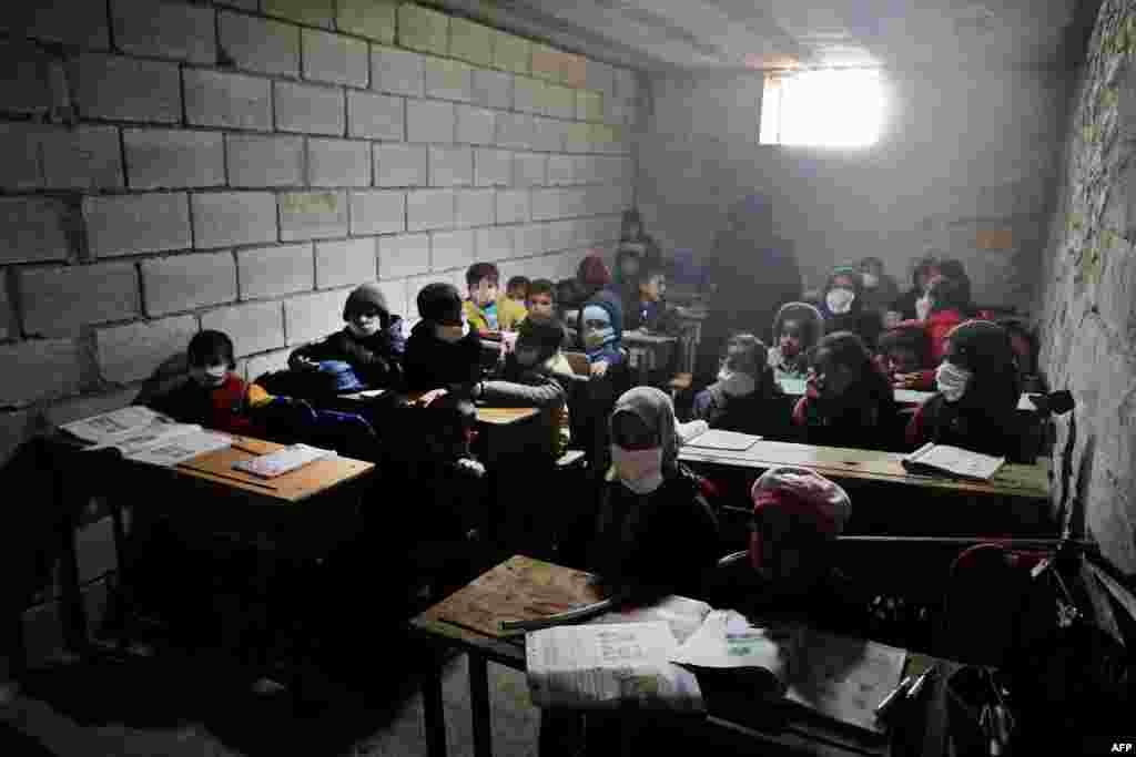 Syrian school children, wearing masks due to the COVID-19 pandemic, sit at a makeshift school set up by locals in the village of Ma'arin on the outskirts of Azaz in the rebel-controlled northern countryside of Syria's Aleppo province.