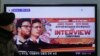 韩国一名军人走在首尔火车站索尼公司影片【采访】的电视广告屏幕附近。