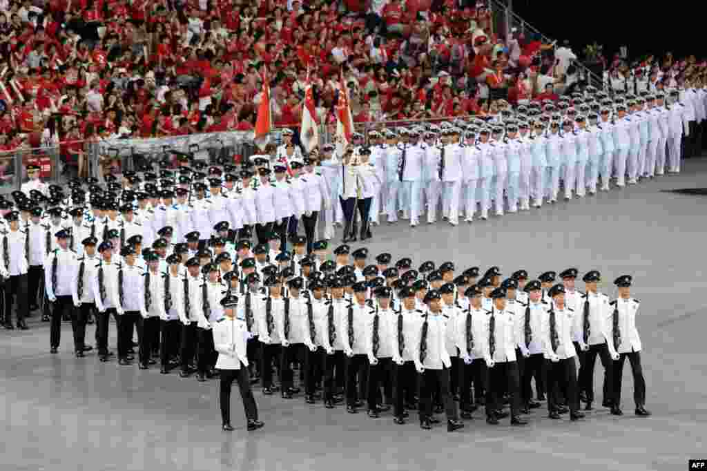 Contingents march inside the national stadium during National Day celebrations in Singapore. Singapore celebrated its 51st anniversary as a republic under tight air, sea and land security after the discovery of an Indonesian extremist plot to attack the city-state.