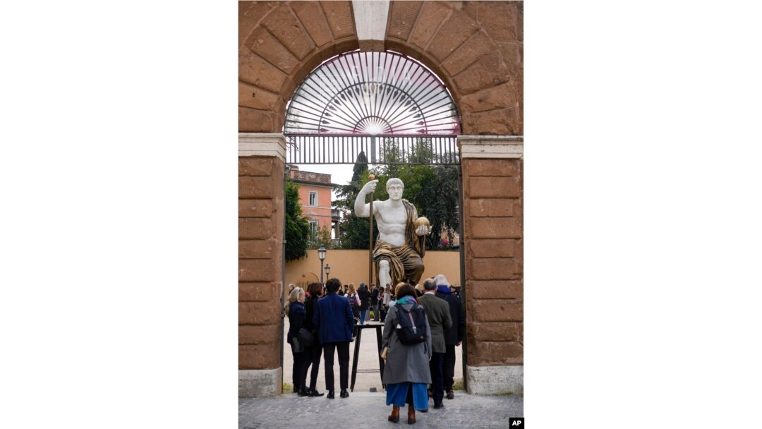 Visitors admire a massive, 13-meter replica of the statue of Roman Emperor Constantine in Rome, Tuesday, Feb. 6, 2024. . (AP Photo/Andrew Medichini)