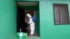A health worker, wearing a protective suit, disinfects a house during an Ebola prevention drill at the port in Monrovia, Liberia, Aug. 29, 2014. 