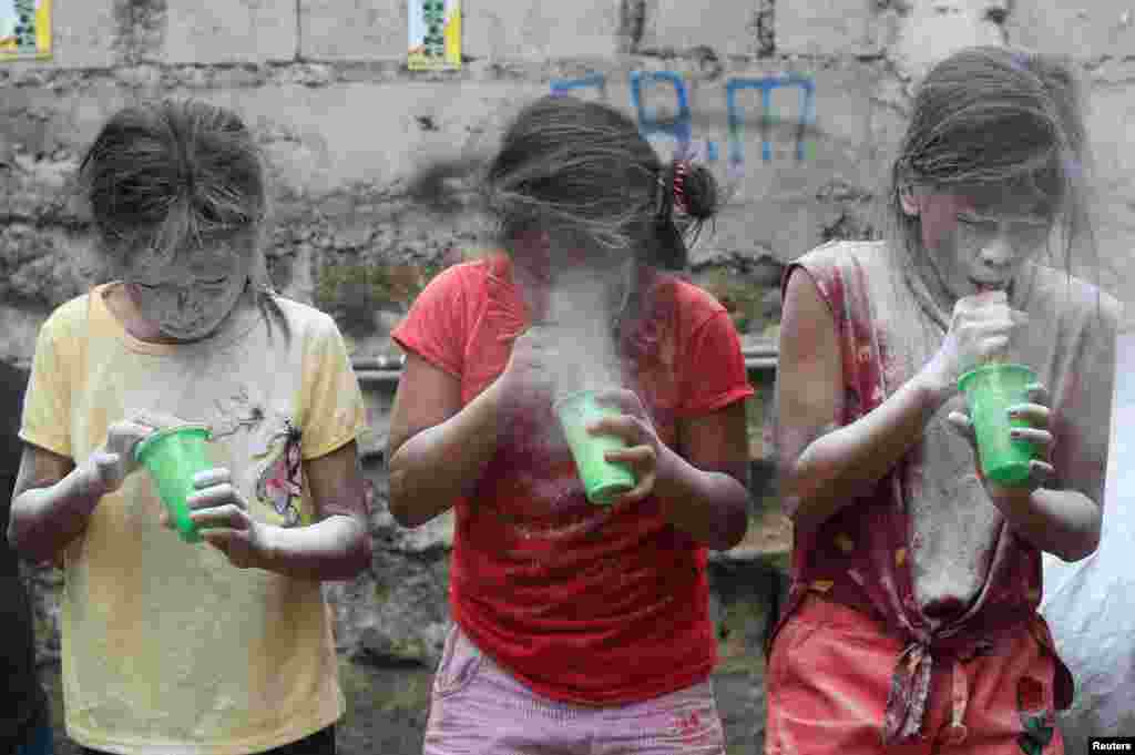 Girls' faces are covered by white powder at a town fiesta parlour game, in celebration of patron saint Santa Rita de Cascia in Baclaran, Paranaque City, Metro Manila, Philippines.