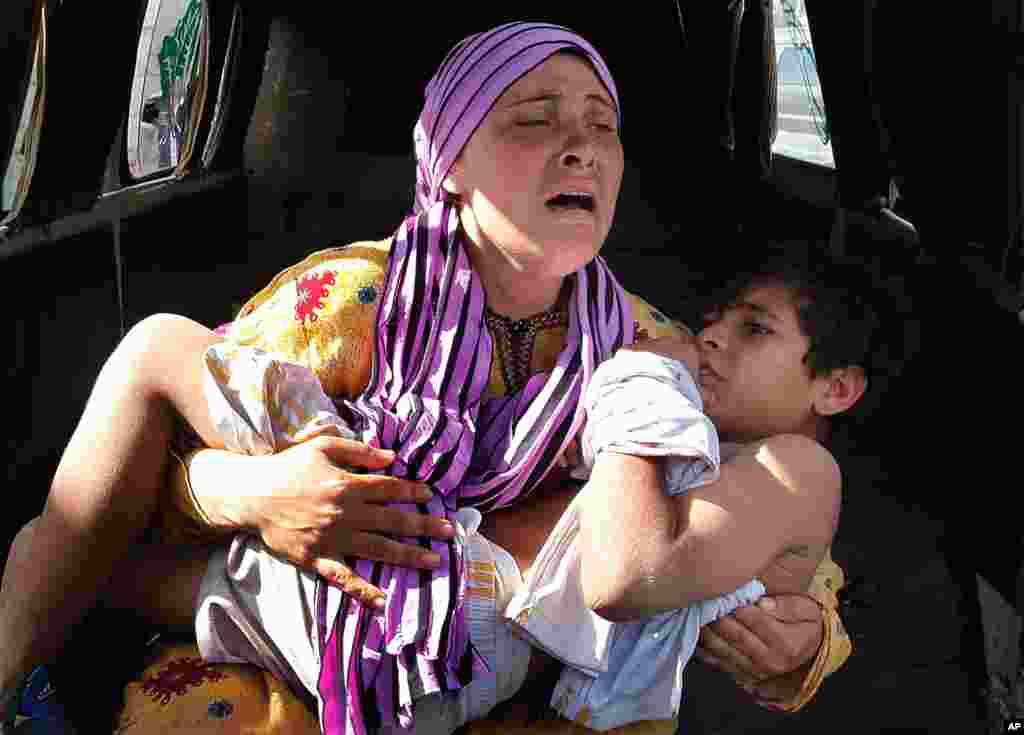 30/5/2012: Bà mẹ Syria ẵm đưa con bị binh sĩ biên phòng Syria bắn bị thương nơi tay trong lúc vượt biên để đến Libăng.