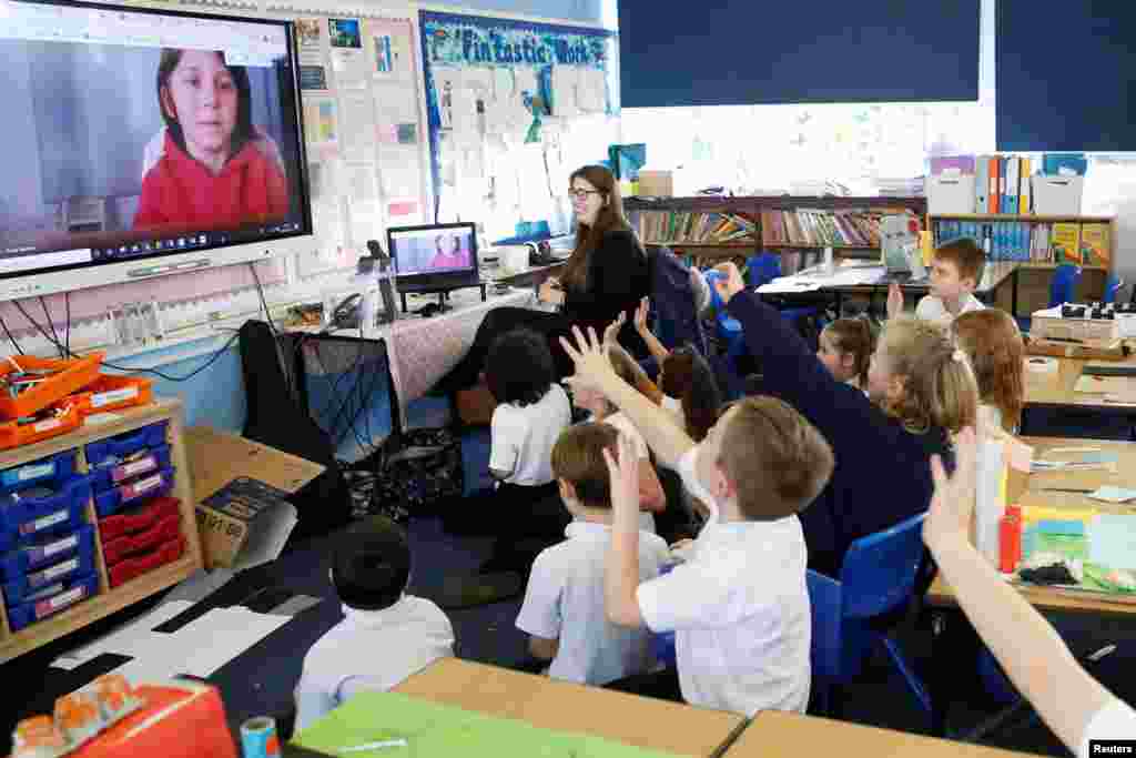 Students at Holne Chase School interact with a class member via the internet as his family is self-isolating amid the Covid-19 pandemic in Milton Keynes, Britain.