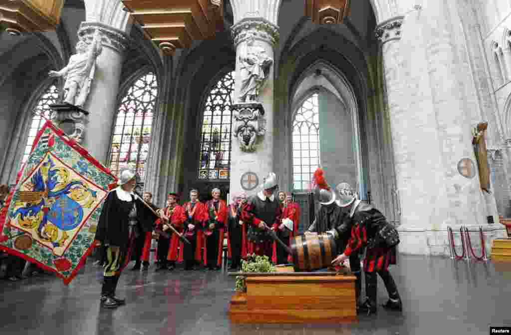 Members of the Knighthood of the Brewers' Mash staff carry a barrel of beer inside the Sint-Gudule Cathedral in Brussels, Belgium, during celebrations of Saint-Arnould, patron saint of brewers.