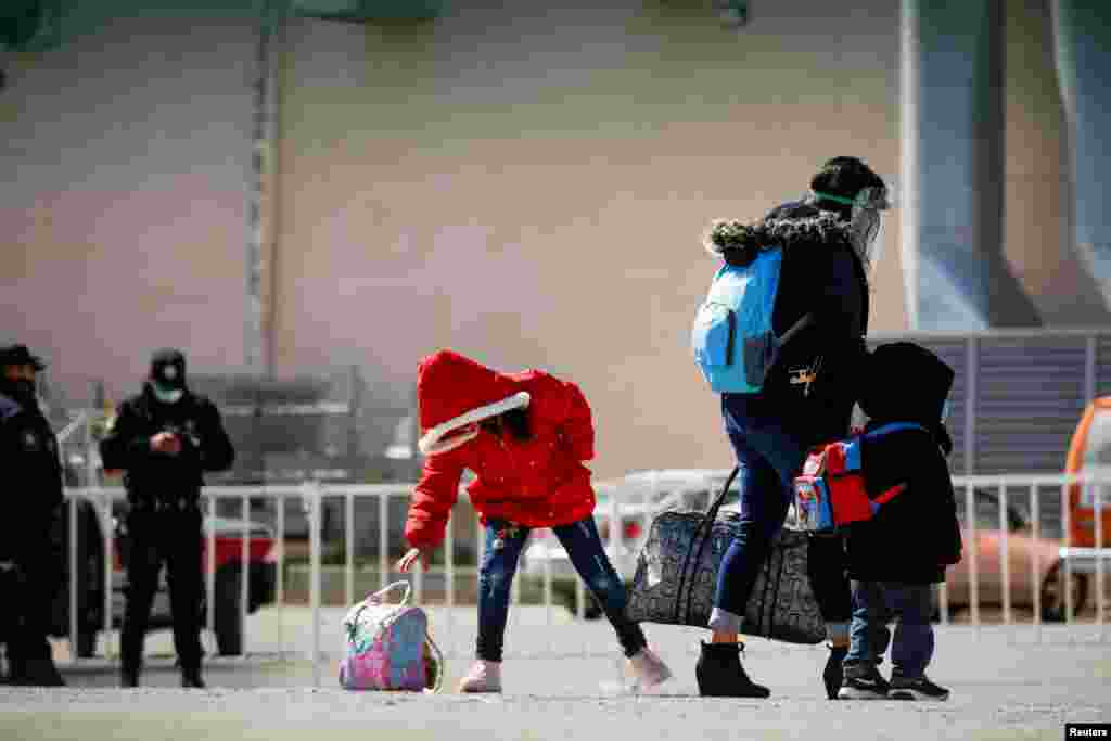 Migrants under the Migrant Protection Protocols (MPP) program wait to take a test for COVID-19 at the Leona Vicario temporary migrant shelter in Ciudad Juarez, Mexico, before being transferred to continue their asylum request in the United States, March 1, 2021.