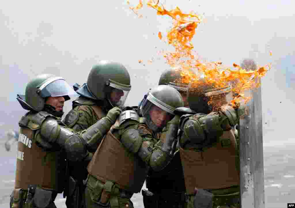Chilean riot policemen protect themselves with shields during clashes with students who demand the government of Chilean President Sebastian Pinera to improve the public education system, in Santiago, March 7, 2013.