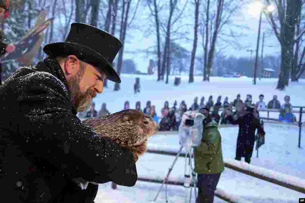 Groundhog Club handler A.J. Dereume holds Punxsutawney Phil, the weather prognosticating groundhog, during the 135th celebration of Groundhog Day on Gobbler's Knob in Punxsutawney, Pennsylvania. Phil's handlers said that the groundhog has forecast six more weeks of winter weather.