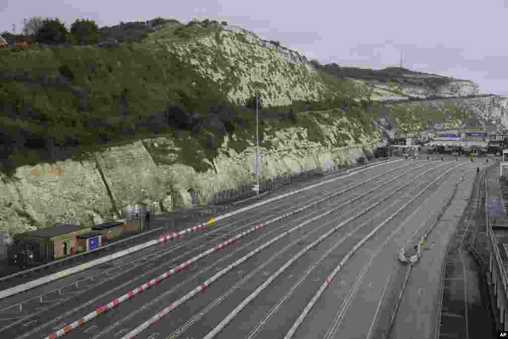 The ferry terminal check-in is seen empty alongside the White Cliffs of Dover, as the Port remains closed, in Dover, southern England. Dozens of countries around the world slapped tough travel restrictions on the U.K. because of a new and seemingly more contagious strain of the coronavirus in England.