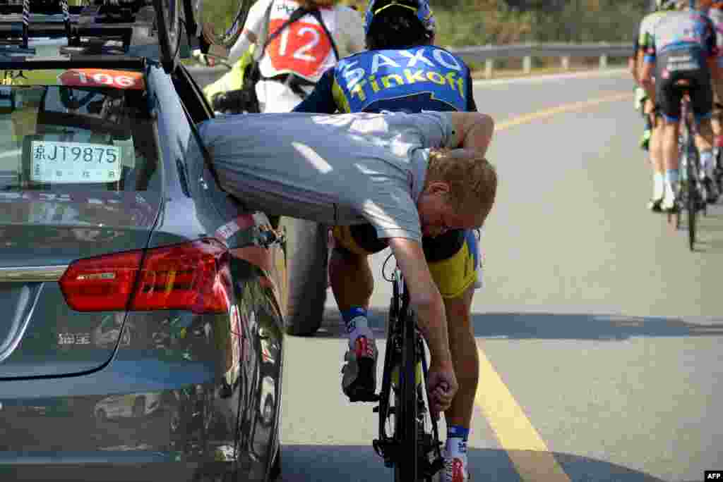Seorang staf tim Saxo Tinkoff memperbaiki sebuah sepeda peserta perlombaan Tour of Beijing 2013 di China.