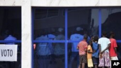 Các thiếu niên xem các viên chức phụ trách bầu cử trong thủ đô của Guinea Bissau đếm phiếu