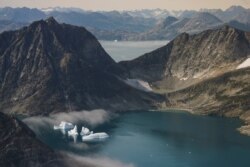 In this photo taken on Wednesday, Aug. 14, 2019, icebergs are photographed from the window of an airplane carrying NASA Scientists as they fly on a mission to track melting ice in eastern Greenland.