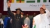 Nigeria's President Goodluck Jonathan (L) and Niger's President Mahamadou Issoufou wave while taking part in a regional summit focused on the fight against Nigerian Islamist extremist group Boko Haram, Oct. 7, 2014 in Niamey.