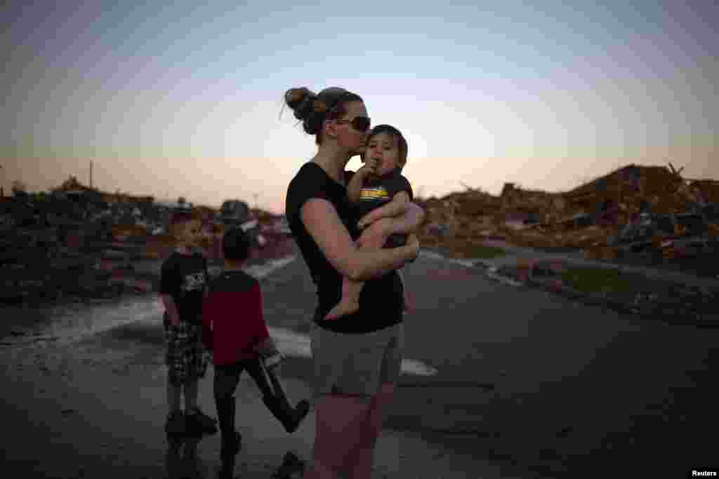 Rae Kittrell holds her son Rylan, who turned one-year-old two days after the tornado, a block away from her house in Moore, Oklahoma, May 22, 2013.