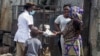 A health worker, center, distributes leaflets on how people should protect themselves from the new coronavirus, in Lagos, Nigeria, March 31, 2020.