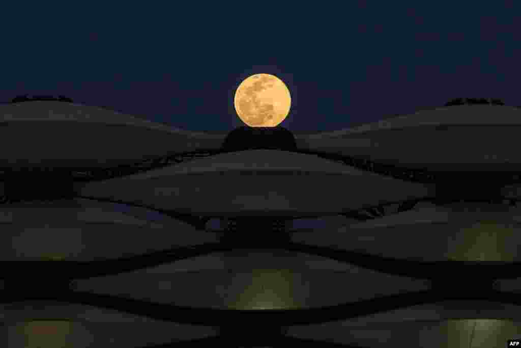 A view of the rising full "Worm Moon" above Basra International Stadium in the southern Iraqi city, March 28, 2021.