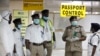 FILE - In this photo from Aug. 4, Nigerian port health officials wait to screen passengers at the arrivals hall of Murtala Muhammed International Airport in Lagos. 