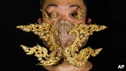 Edmond Kok, a Hong Kong theater costume designer and actor, wearing a face mask inspired by the decoration of Thai temple to Kok's face in Hong Kong Thursday, Aug. 6, 2020. With little theater work…