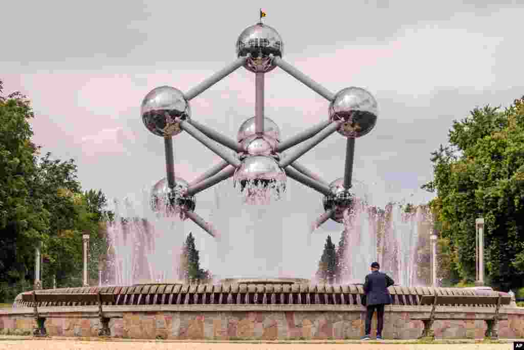 A tourist looks at a fountain at the Atomium in Brussels, Belgium.