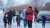 Inmigrantes corren bajo la lluvia hacia las tiendas de campaña en el alojamiento para inmigrantes en Floyd Bennett Field, el martes 9 de enero de 2024, en el distrito de Brooklyn en Nueva York. (Foto AP/Mary Altaffer)