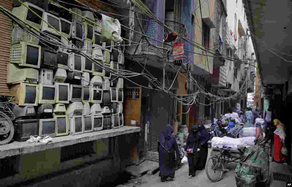 FILE - Discarded television sets are stacked up in an alleyway in an area known for storing electronic waste in New Delhi, India, Dec. 8, 2018.