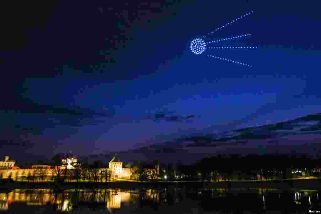 Drones forming a figure of the first artificial Earth satellite "Sputnik 1" light up the evening sky on the eve of Cosmonautics Day in Veliky Novgorod, Russia, April 11, 2021. (Press service of the Government of the Novgorod region/Handout)