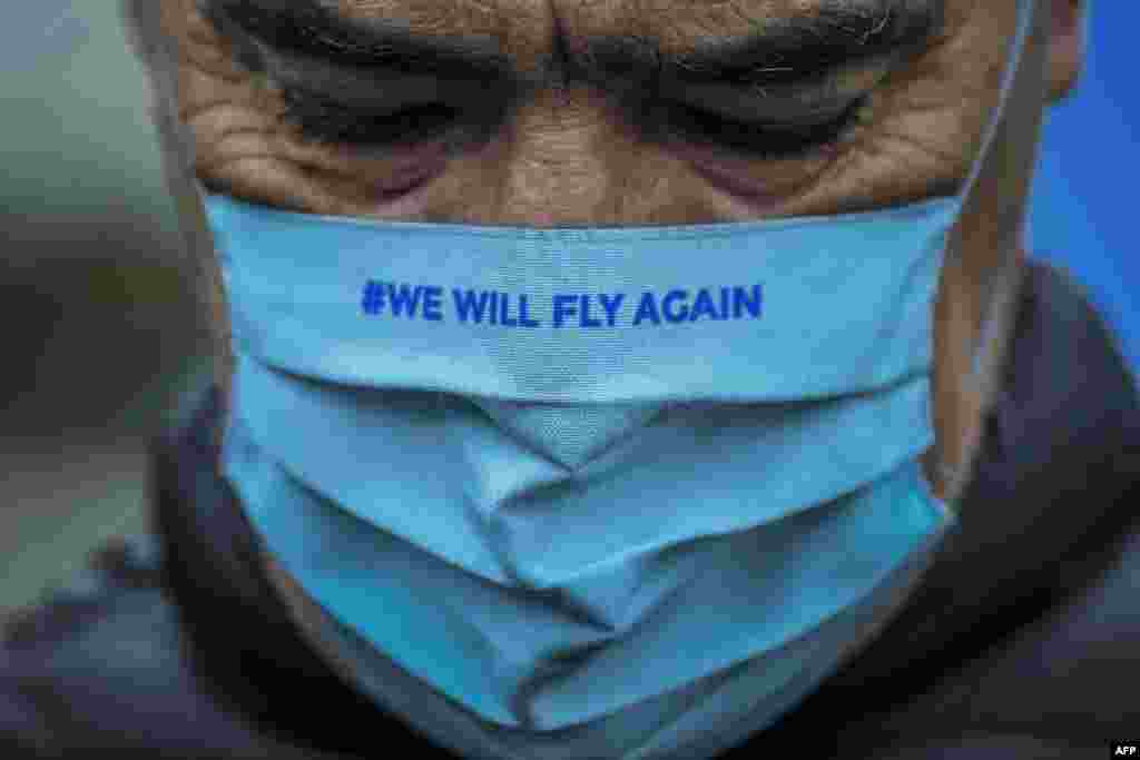 A TAP Air Portugal employee wearing a face mask reading "We will fly again" takes part in a protest against job cuts at TAP airline headquarters in Lisbon, Portugal.