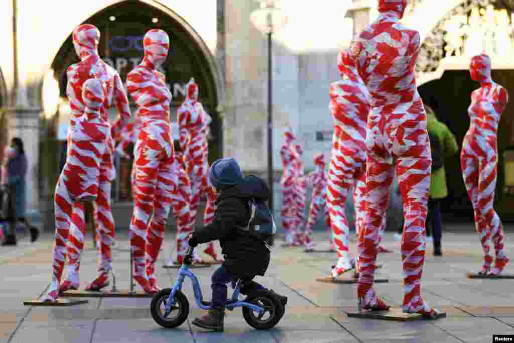 A little boy looks at an art installation with 111 mannequins on Marienplatz calling for more "mindfulness and appreciation" in times of the pandemic in Munich, Germany.