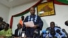 Opposition leader Jean Hubert Bazie (C) reads a statement, next to the head of Burkina Faso's opposition Zephirin Diabre (D), during a press conference on Nov. 1, 2014 in Ouagadougou. 