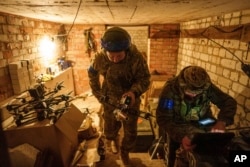 Ukrajinski vojnik, zvani Manul, nosi "samoubilački" FPV dron do pozicije uzletanja pre leta iznad ruskih položaja u oblasti Harkov, Ukrajina, 13. maja 2024. (AP Photo/Evgenii Maloletka)
